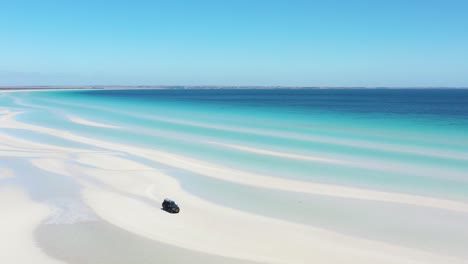 Excellent-Aerial-Shot-Of-A-Van-Parked-On-The-White-Sands-Near-The-Clear-Blue-Water-Of-Flaherty-Beach-On-Yorke-Peninsula,-Australia