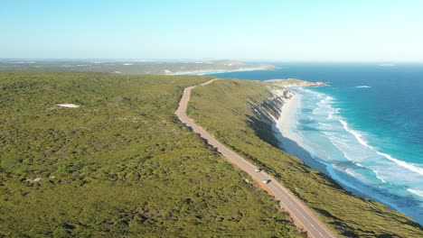 Excellent-Aerial-Shot-Of-Cars-Driving-Along-Great-Ocean-Drive-In-Esperance,-Australia