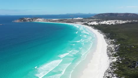 Excellent-Aerial-Shot-Of-Far-Away-Cars-Driving-On-The-White-Sands-Of-Wharton-Bay-As-Clear-Blue-Water-Laps-The-Shore-In-Esperance,-Australia
