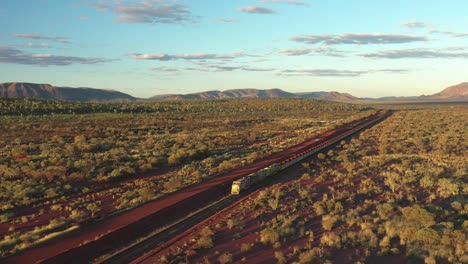 Excellent-Aerial-Shot-Of-A-Coal-Train-Traveling-Through-Tom-Price,-Australia