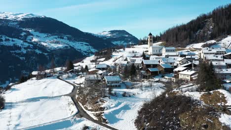 Excelente-Vista-Aérea-De-La-Ciudad-Montañosa-Cubierta-De-Nieve-De-Alvaneu,-Suiza