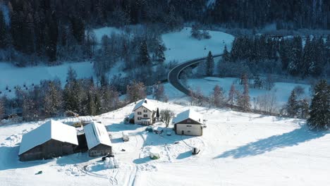 Excelente-Vista-Aérea-De-Un-Automóvil-Que-Pasa-Por-Casas-En-Landwasser-Invernal,-Suiza