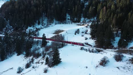 Excellent-Aerial-View-Of-A-Train-Traveling-Across-A-Snowy-Mountain-In-Switzerland
