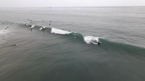 Excelente-Vista-Aérea-De-Surfistas-Nadando-Hacia-Las-Olas