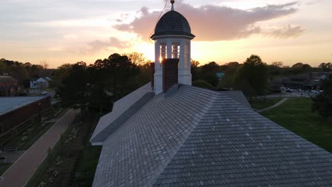 Excellent-Aerial-View-Of-A-Historic-Building-Topped-With-A-Weather-Vane-At-Sunset-In-Williamsburg,-Virginia