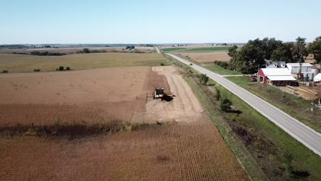 Aerial-Drone-Footage-Of-A-Farmer-Driving-A-Combine-Harvester-In-A-No-Till-Corn-Field-In-Rural,-Midwest-Iowa-Farm-Country