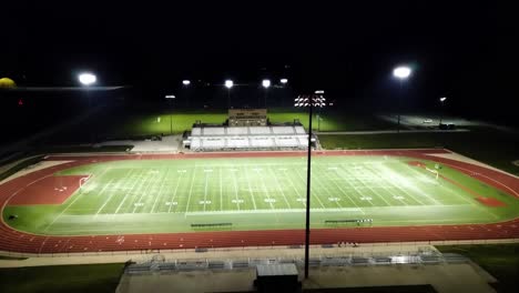 Nighttime-Aerial-Drone-Footage-Football-Field-At-Statesmen-Community-Stadium-William-Penn-University,-Oskaloosa,-Iowa