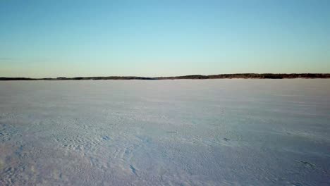 Drohnenaufnahmen-Von-Schnee-Und-Eis-Auf-Einem-Zugefrorenen-Gewässer-An-Einem-Kalten-Wintertag-Im-Ländlichen-Mittelwesten-Von-Iowa