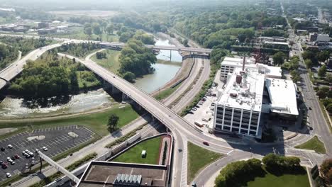 Aerial-Drone-Footage-Of-A-River,-Roads-And-Intersection,-Buildings-And-Woodland-In-Iowa