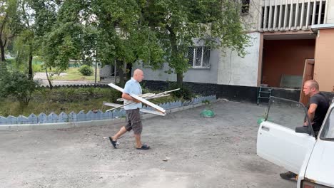 Während-Des-Ukrainekriegs-Sammeln-Männer-Zertrümmerte-Teile-Ihrer-Häuser-Im-Gebiet-Von-Charkiw-In-Saltivka