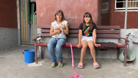 Eine-Frau-Und-Ihre-Tochter-Sitzen-Mit-Ihrer-Katze-Vor-Einer-Zerstörten-Wohnung-Im-Bezirk-Saltivka-In-Charkiw,-Ukraine