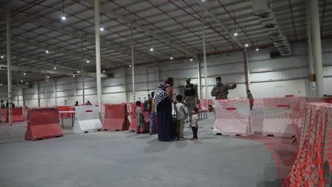 Soldados-Del-Ejército-Estadounidense-Dan-La-Bienvenida-Y-Ayudan-A-Los-Evacuados-Afganos-Que-Llegan-Al-Campamento-Como-Sayliyah,-Qatar