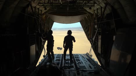 Los-Tripulantes-De-La-Fuerza-Aérea-De-Los-Estados-Unidos-Lanzan-Paquetes-De-Paracaídas-Sobre-El-Desierto-Desde-Un-C-130j-Super-Hercules,-áfrica-Oriental