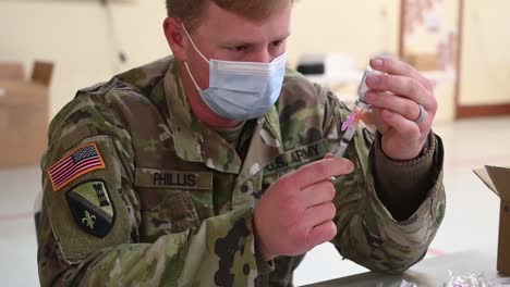 Us-Army-Medical-Soldiers-Draw-From-Vials-For-Innoculating-And-Injecting-People-Covid-19-Pandemic-Vaccines