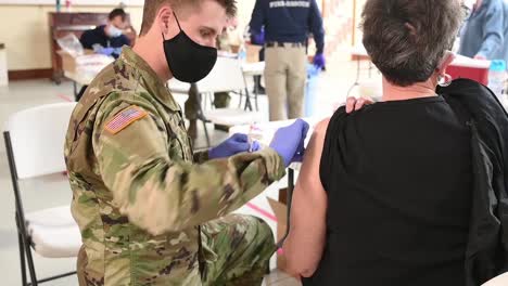 Us-Army-Medical-Soldiers-Innoculate-And-Inject-A-Woman-With-The-Covid-19-Pandemic-Vaccine
