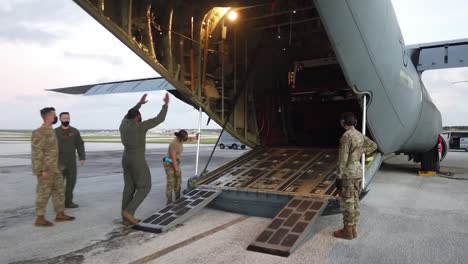 Los-Aviadores-De-La-Fuerza-Aérea-Estadounidense-En-La-Base-De-La-Fuerza-Aérea-Andersen-Cargan-Productos-Químicos-En-El-Asfalto-Del-Avión-C-130-Hercules,-Guam