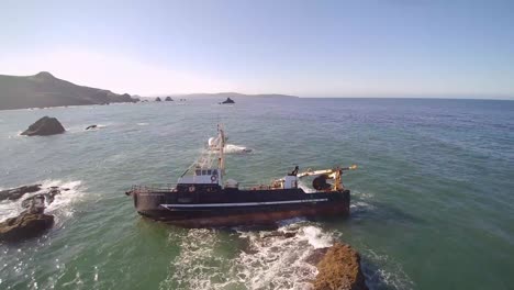Aerial-Drone-View-Of-The-American-Challenger,-A-Vessel-That-Ran-Aground-On-The-Rocky-Shore-Near-Dillon-Beach,-Ca
