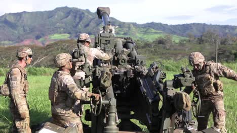 Soldaten-Der-US-Armee-Laden-Und-Feuern-Die-Haubitze-M777-Ab-Und-Steigen-Während-Der-Militärischen-Angriffsübung-Aus-Dem-Hubschrauber-Aus,-Hawaii