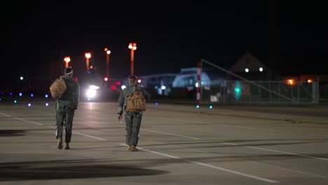 48Th-Fighter-Wing-Fighter-Jet-Pilots-Walk-Across-A-Runway-At-Night,-Royal-Air-Force-Lakenhealth,-England