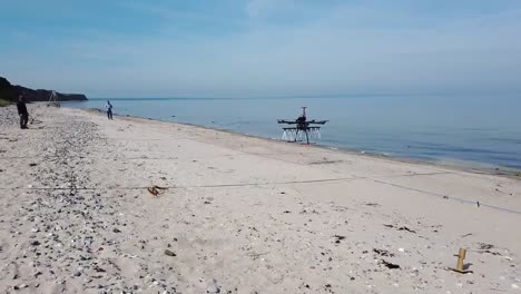 Aerial-Drone-Footage-Of-High-Technology,-Ground-Penetrating-Radar-Sky-Glass-Mounted-On-A-Drone,-Flys-Test-Patterns-On-A-Beach-In-Kiel,-Germany