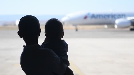 Slow-Motion-Footage-Of-Afgan-Refugees-Boarding-An-American-Airlines-Plane-Outbound-From-Sigonella-Naval-Air-Station,-Italy