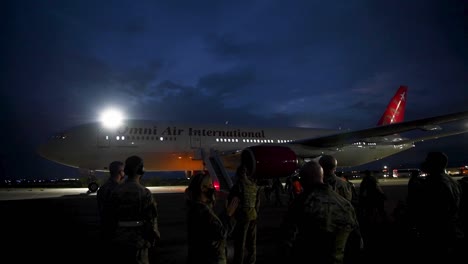 Nächtliche-Aufnahmen-Von-Holloman-Afb-personal-Und-Ankommenden-Afghanischen-Flüchtlingen,-Die-Nach-Der-Flucht-Aus-Afganistan-Ein-Zivilflugzeug-Verlassen