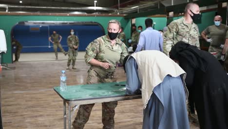 Us-Soldiers-Provide-Covid-19-Tests-And-Vaccines-To-Afgan-Evacuees,-Operation-Allies-Refuge-At-Camp-As-Sayliyah,-Qatar