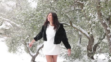A-Young-Woman-In-A-Short-Dress-Delights-In-The-Falling-Snow-Around-Her