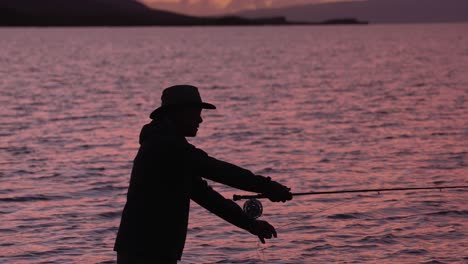 A-Fly-Fisherman-In-Silhouette-Tosses-His-Reel-At-Sunset-In-Molokai,-Hawaii