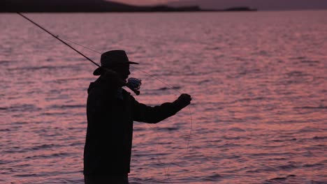 Ein-Fliegenfischer-In-Silhouette-Wirft-Seine-Rolle-Bei-Sonnenuntergang-In-Molokai,-Hawaii