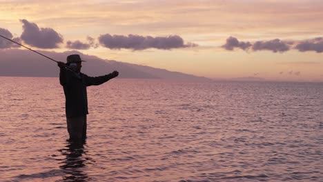 Slow-Motion-Is-Employed-To-Show-A-Full-Shot-Of-Fly-Fisherman-In-Silhouette-At-Sunset-In-Molokai,-Hawaii