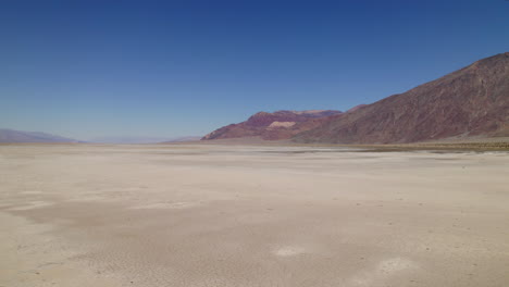 Aerial-Low-Flying-Across-Desert-Landscape-Onto-Dry-Arid-Lake-Bed