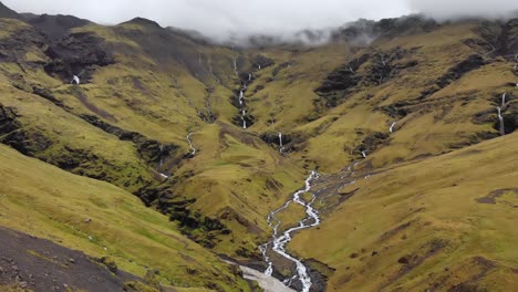 Antena-De-Montañas-Nubladas-Con-Pequeños-Arroyos-De-Agua-En-Islandia
