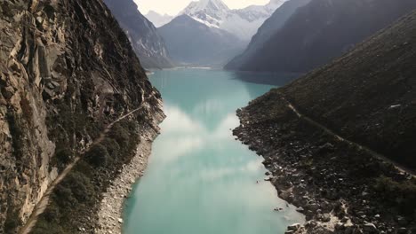 Lake-Paron-Peruvian-Andes-Aerial-Drone-Between-Mountains,-Peru-Crystalline-Water-Andean-Cordillera-Blanca,-Huascaran-National-Park