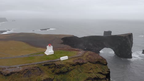 Aerial-of-Dyrhólaey-viewpoint-cliff-near-the-sea-Iceland-white-lighthouse