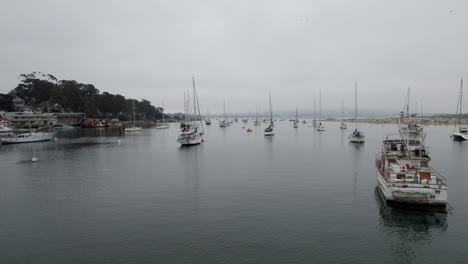 Aerial-Low-Flying-In-Between-Moored-Boats-In-Marina-In-California-On-Overcast-Day