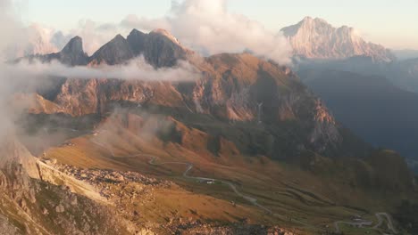 Scenic-aerial-in-Italian-Dolomites-toward-Monte-Cernera,-low-moody-clouds-sunset