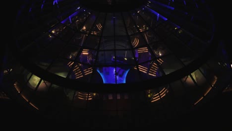 High-angle-shot-over-a-cruise-ship-with-front-indoor-pool-at-night-time