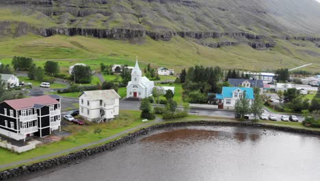 aerial-flying-over-Seydisfjordur-villege-in-Iceland-with-a-small-church
