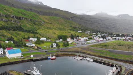 Aerial-of-port-Seydisfjordur-town-in-Iceland-with-dramatic-mountains-background