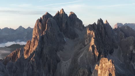 Tight-aerial-view-of-impressive-Cadini-di-Misurina-peaks-at-sunrise,-Dolomites