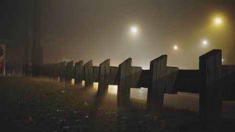 Wooden-Barrier-At-Side-Road-With-Light-Shadow-Of-Driving-Cars-At-Night