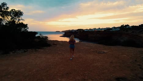 Female-Jogging-To-Edge-Of-Cliff-To-Witness-Golden-Hour-Sunset