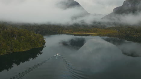 Incredible-drone-shot-overlooking-a-small-boat-travelling-through-the-Rio-Manso-river-in-Argentina