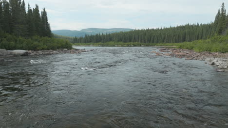 Low-flying-aerial-shot-going-up-a-stream-in-Labrador,-Canada