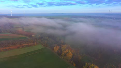 Nebelwolken-über-Der-Herbstlichen-Naturlandschaft-Und-Windkraftanlage-Im-Hintergrund