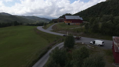 Aerial-shot-of-car-driving-in-the-road-in-the-farmland-of-norway