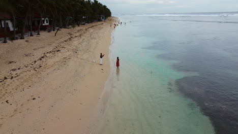 Drone-Flying-Above-Bolinao-Seashore-During-Day-Time-With-People-Having-Fun