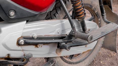 close-up-side-view-of-the-chain-guard-and-rear-wheel-of-a-bajaj-motorcycle-from-india-imported-to-africa