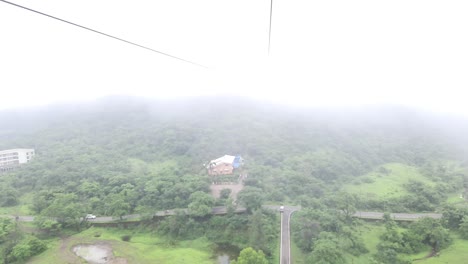 Beautiful-view-from-a-ropeway-car-moving-up-the-mountain-on-a-Cloudy-day,-Cable-Car-In-The-Clouds